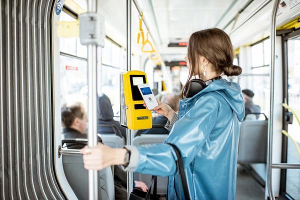 Woman paying conctactless with smartphone for the public transport in the tram